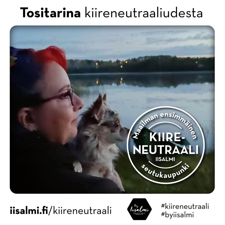 Kuvassa Arja Wäisänen on järven rannalla hämyisenä kesäiltana pidellen sylissään Teppo-koiraansa.