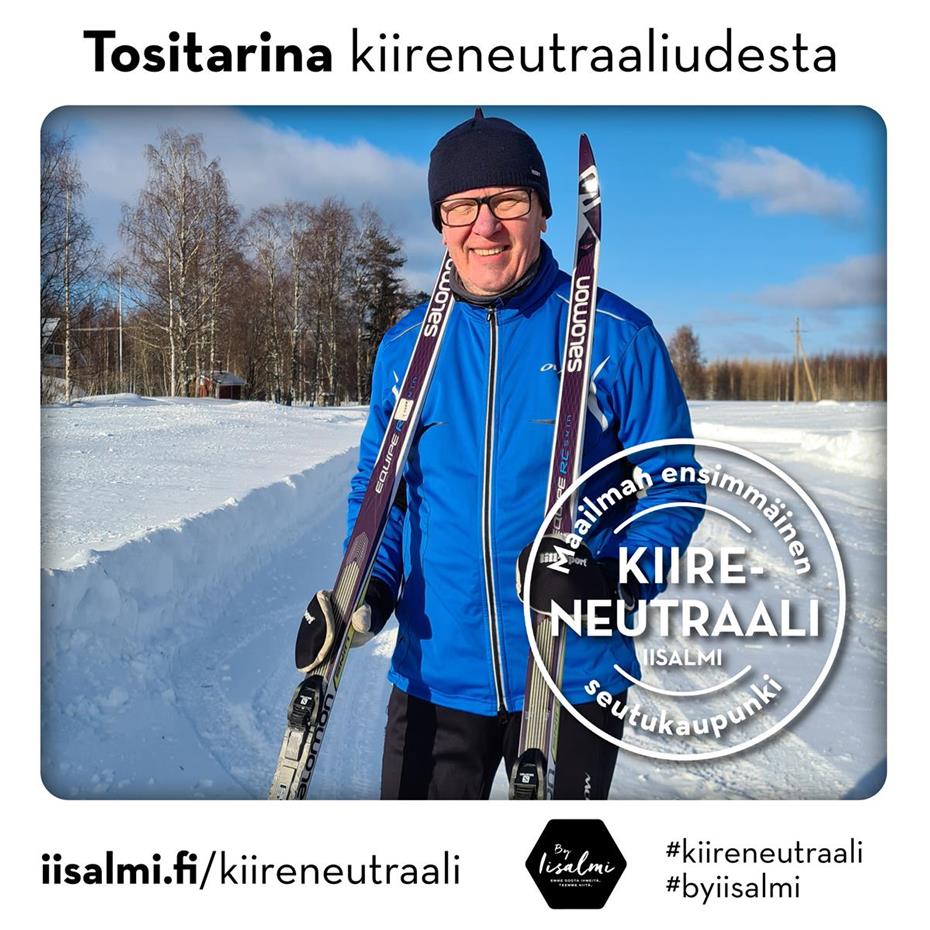 Kuvassa hymyilevä Hannu Juntunen seisoo aurinkoisella hiihtoladulla pidellen käsissään suksia. 
