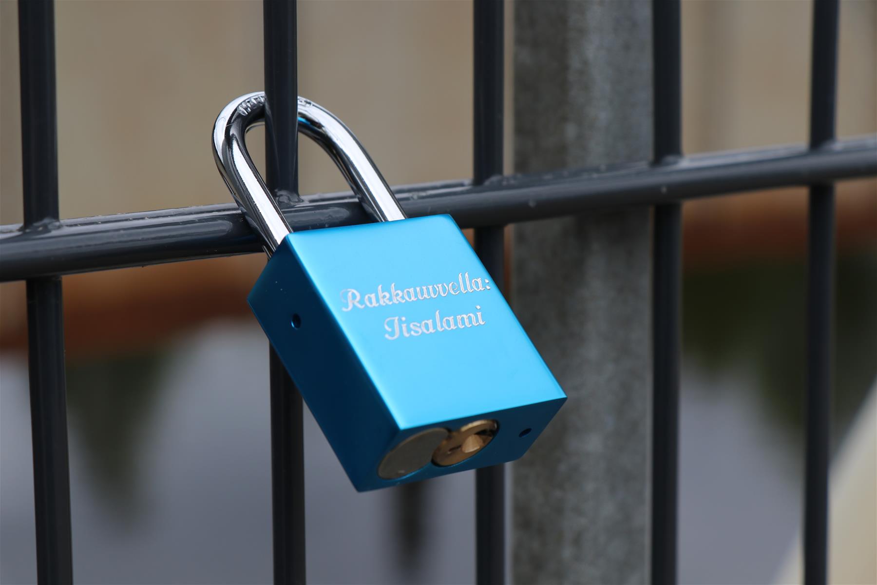 Sininen lukko, jossa on teksti rakkauvvella: Iisalami, riippuu sillan kaiteessa
