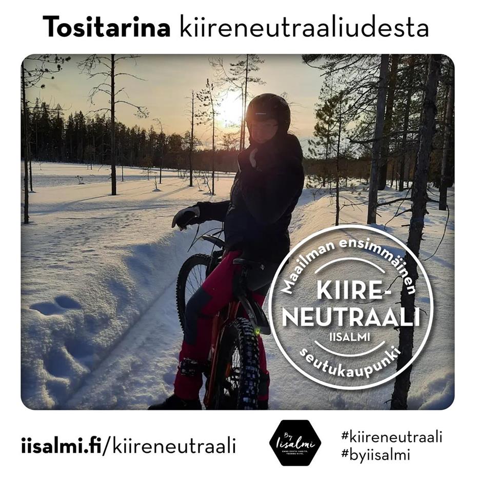 Kuvassa Anne Heikkinen maastopyörän selässä talvisella ja aurinkoisella metsäpolulla.